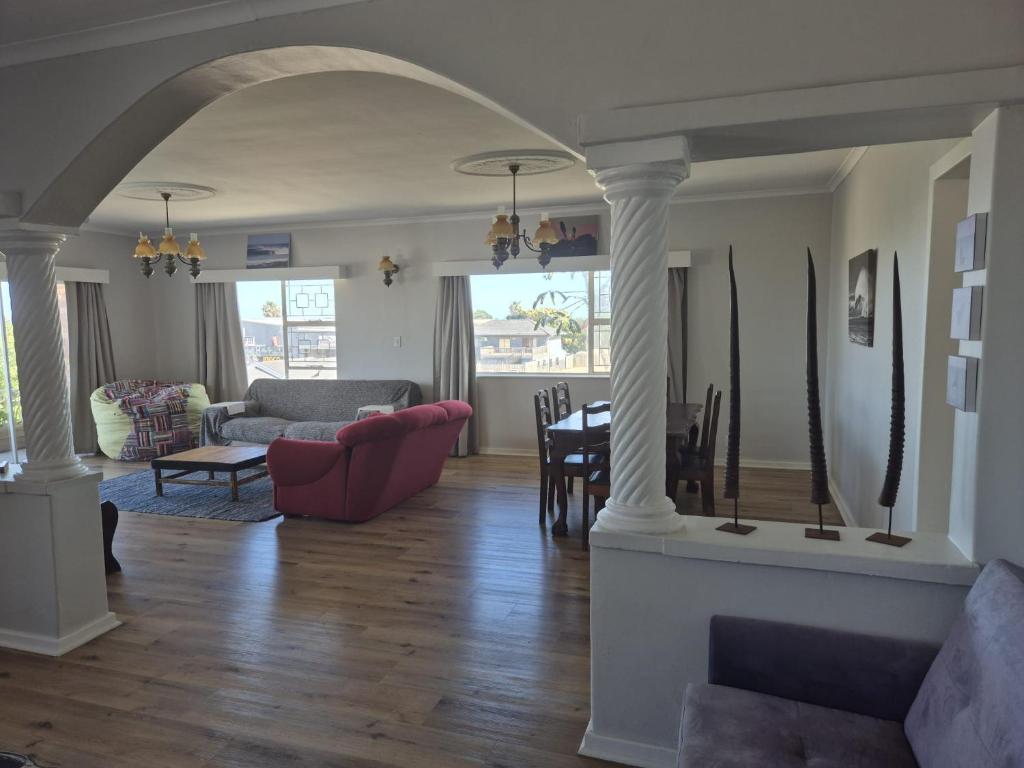a living room with a couch and a table at Magna Apartment in Jeffreys Bay