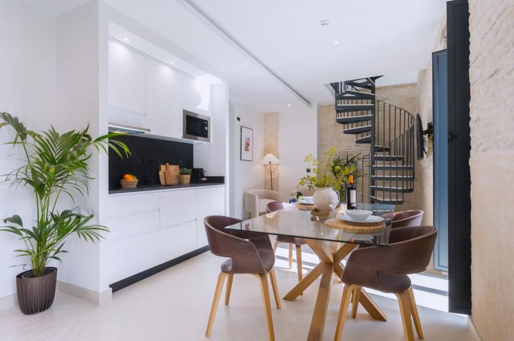 セビリアにあるLuxurious Duplex 2Bd 2Bth over Casa Pilatosのテーブルと椅子のあるキッチンとダイニングルーム