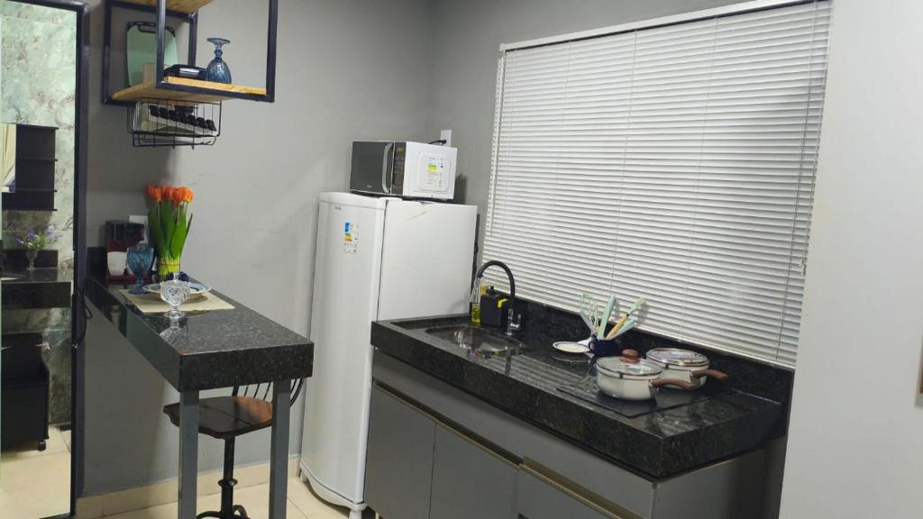 a kitchen with a white refrigerator and a counter at Flats containers in Rio Verde