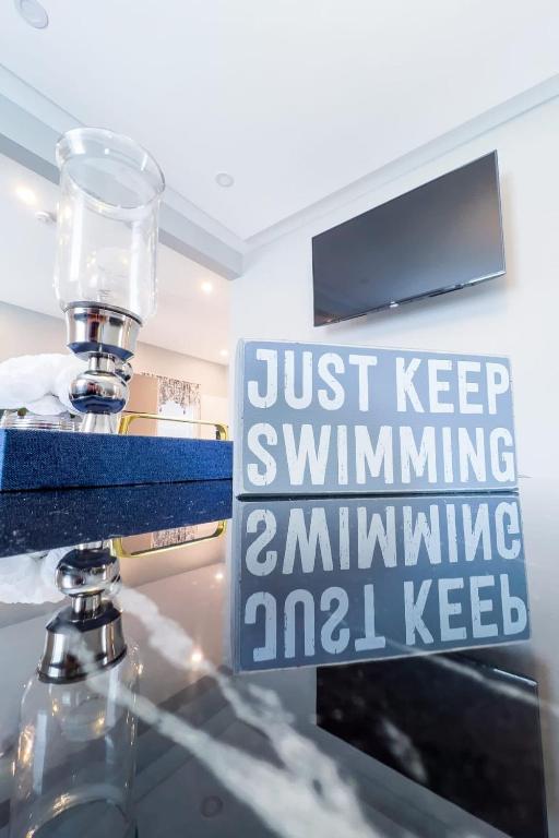 a sign that says just keep swimming swimmingamninkingamdcilcilcilcilcil at Group Friendly 6BR Near Aquarium & Niagara Falls in Niagara Falls