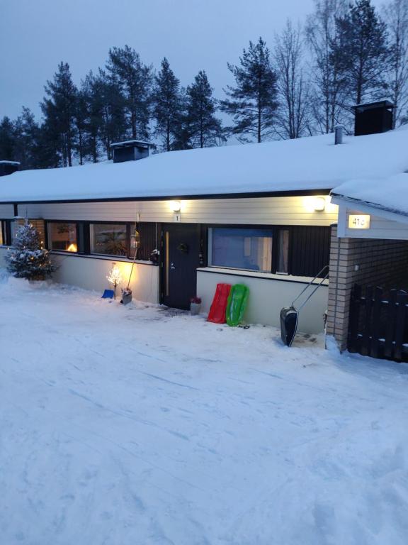 a house with snow on the ground in front of it at A beautiful row house in Rovaniemi