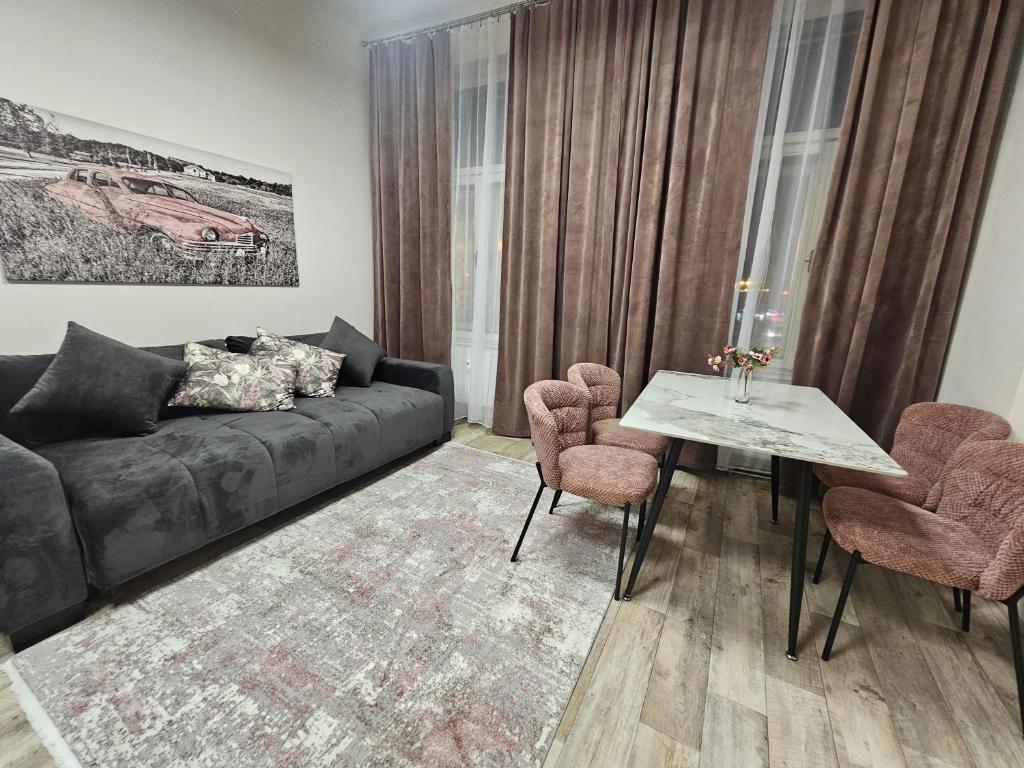 a living room with a couch and a table and chairs at Kompletně vybavený byt s ložnicí v centru u divadla in Golčŭv Jeníkov