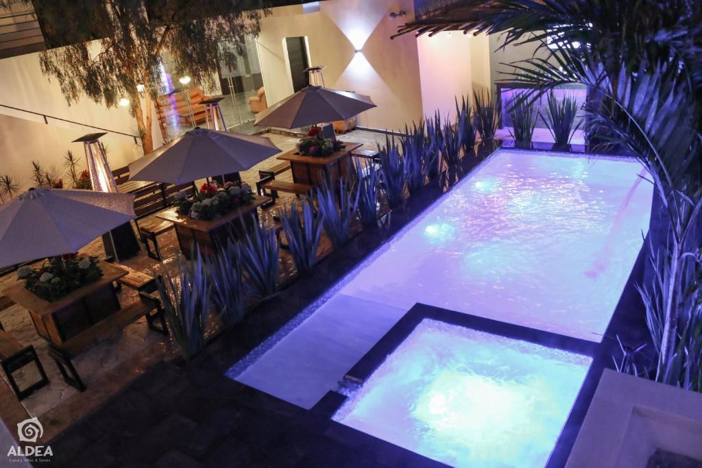an overhead view of a swimming pool with tables and umbrellas at Aldea Express in San Juan Teotihuacán