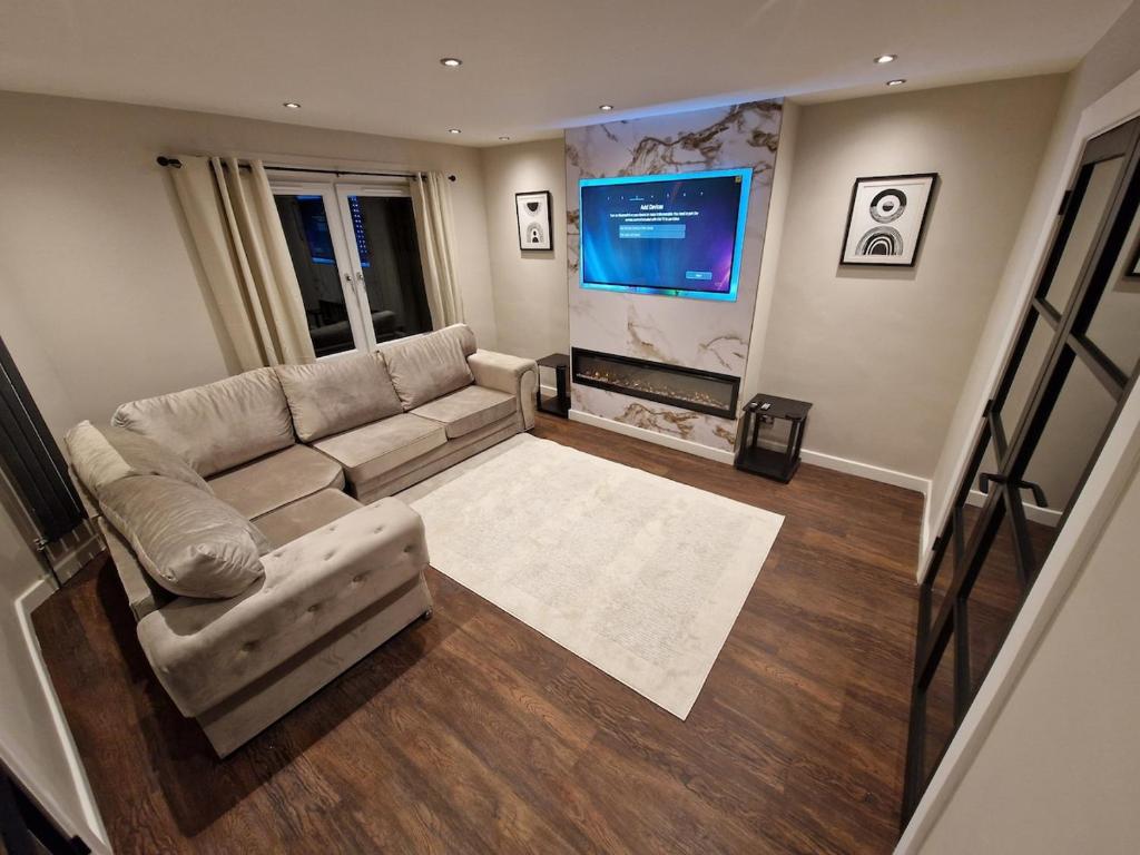 エディンバラにあるEdinburgh West Luxury 5 Bedroom Homeのソファと薄型テレビのあるリビングルーム