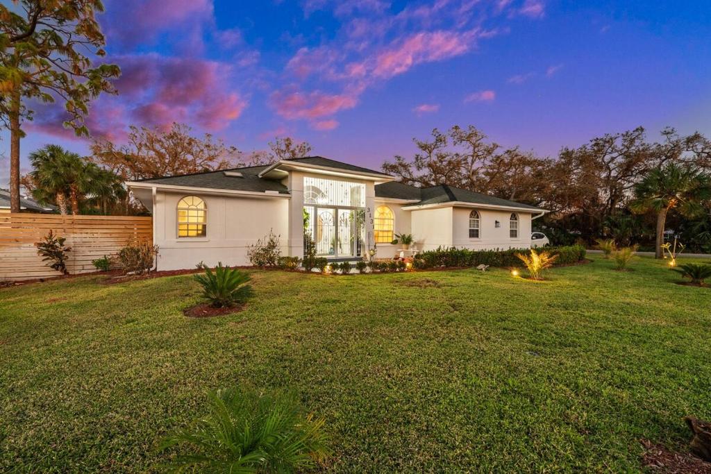 a house in a yard with a grass yard at Sunset Sands Retreat in Venice