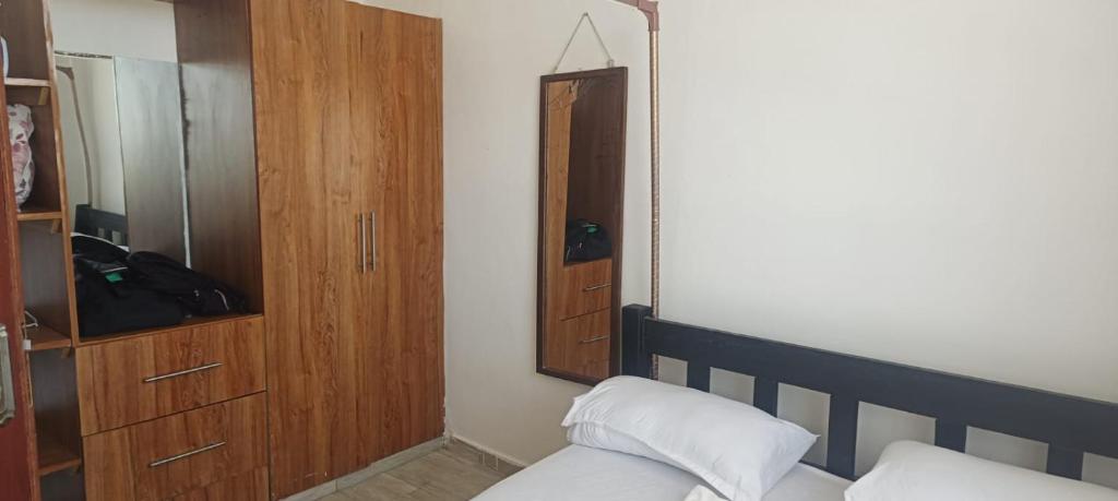 a bedroom with a bed and a wooden cabinet at Cozy one bedroom in Mombasa