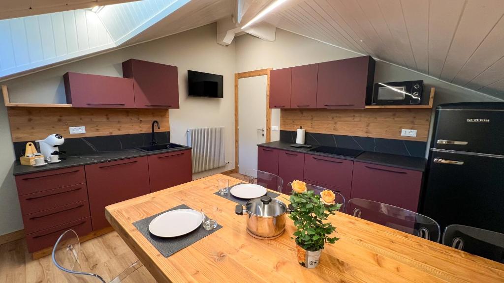 a kitchen with a wooden table and purple cabinets at Harmonia Suite & Apartments in Giustino