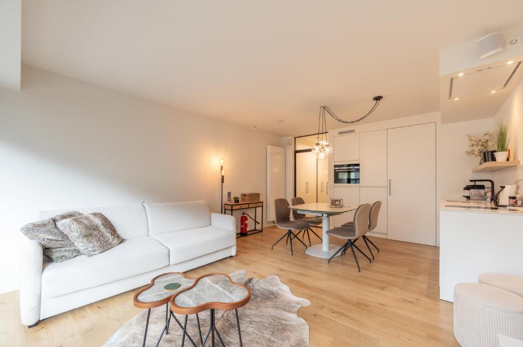 a living room with a white couch and a table at Cosy Coast in Knokke-Heist