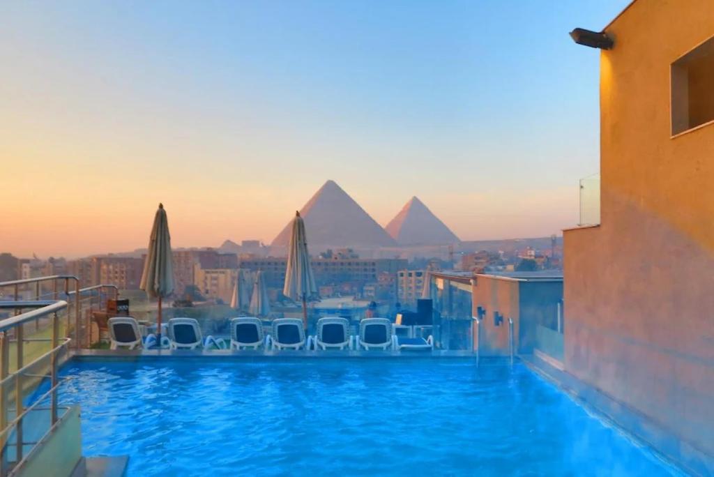 Una vista de las pirámides desde la piscina de un hotel. en Pyramid Front Hotel, en El Cairo