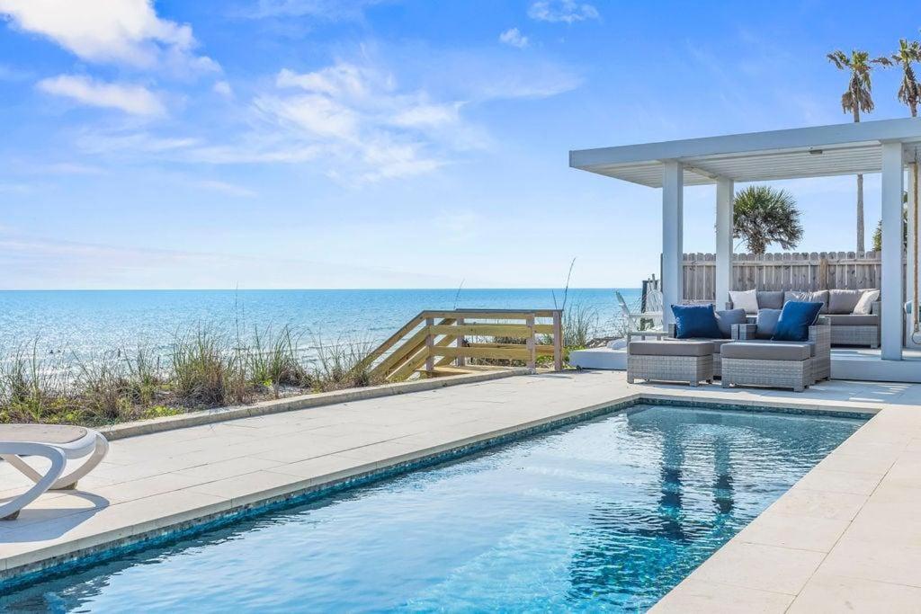 a swimming pool with a view of the ocean at Seaside Retreat in Santa Rosa Beach