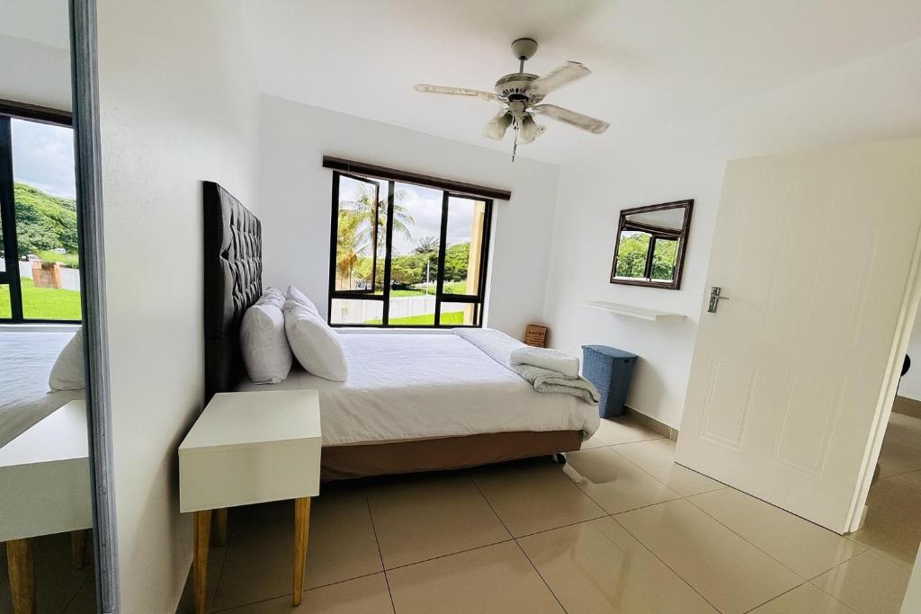 a bedroom with a bed and a window at Tranquil Shores Modern 1BR WiFi Pool Beach in Richards Bay