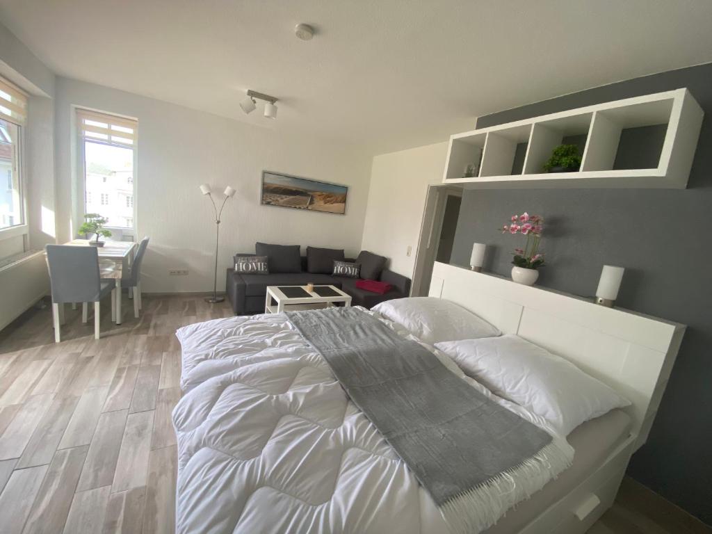 Ostseeoase Zinnowitz - Whg 23 في زينوويتز: غرفة نوم بها سرير كبير وغرفة معيشة