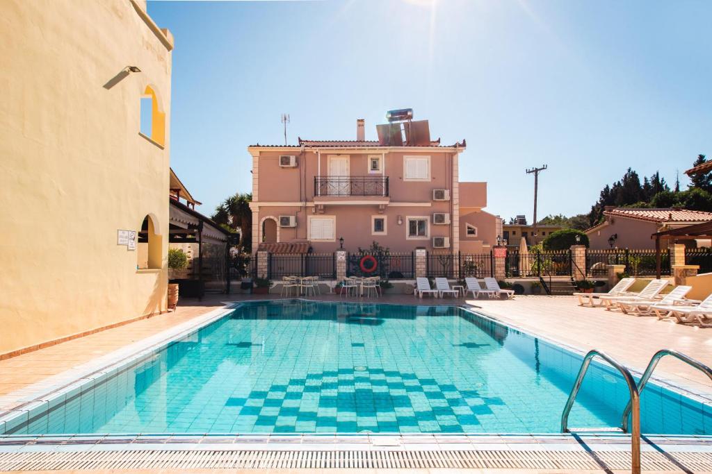 a swimming pool in front of a building at Solena Studios Kavos in Kavos