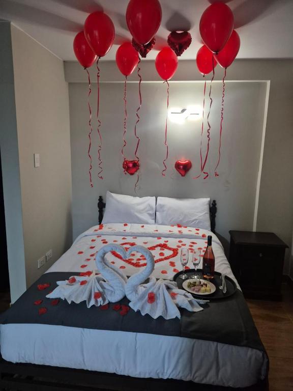 Una cama con globos rojos y dos cisnes encima. en Hotel Naciones Unidas, en Lima