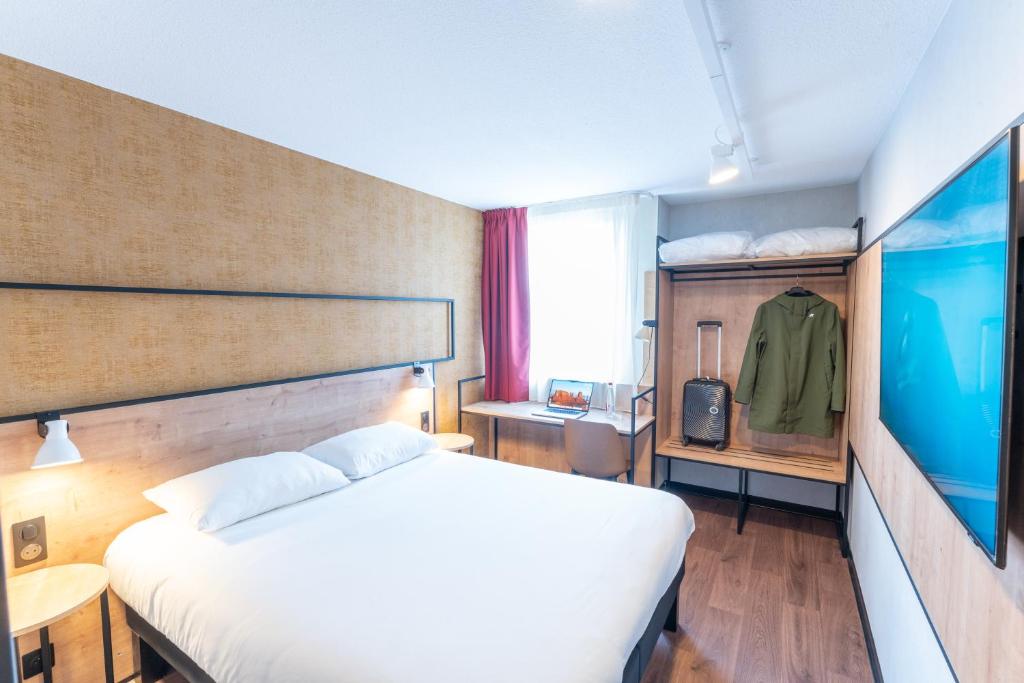 une chambre d'hôtel avec un lit et une télévision dans l'établissement Ibis Orleans La Chapelle Saint Mesmin, à La Chapelle-Saint-Mesmin