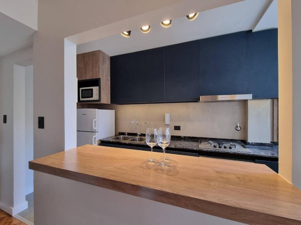 a kitchen with two wine glasses on a counter at Moderno departamento en Cañitas in Buenos Aires