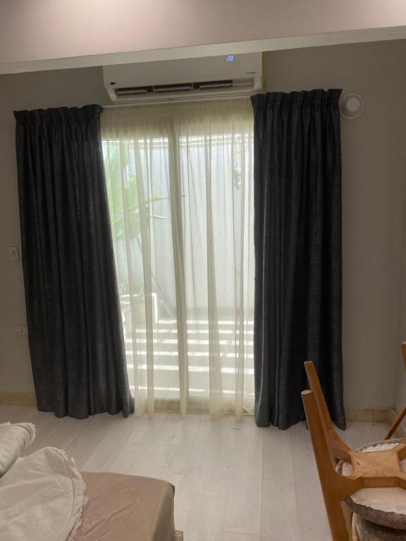 a bedroom with a large window with curtains at Down town 2 in Cairo