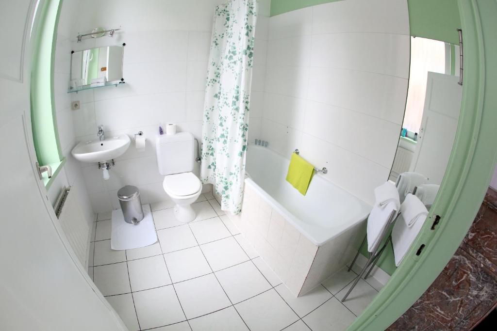 a white bathroom with a sink and a toilet at Eurotel in Liège