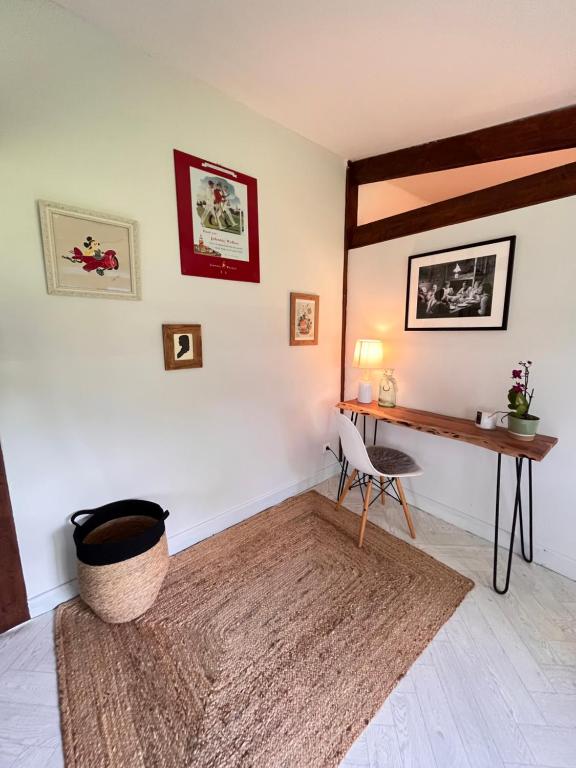 a living room with a desk and a rug at La petite chambre in Mosnay