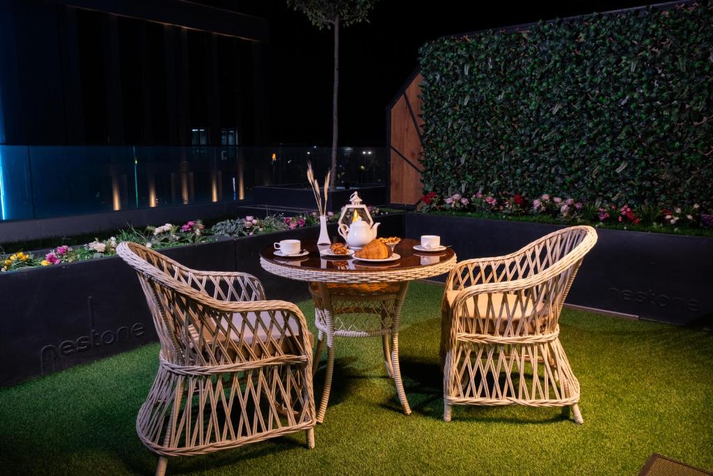 a table and two chairs with a table and a table and chairs at Nest One Luxe, Элитные апартаменты с террасой и панорамным видом 067 in Tashkent