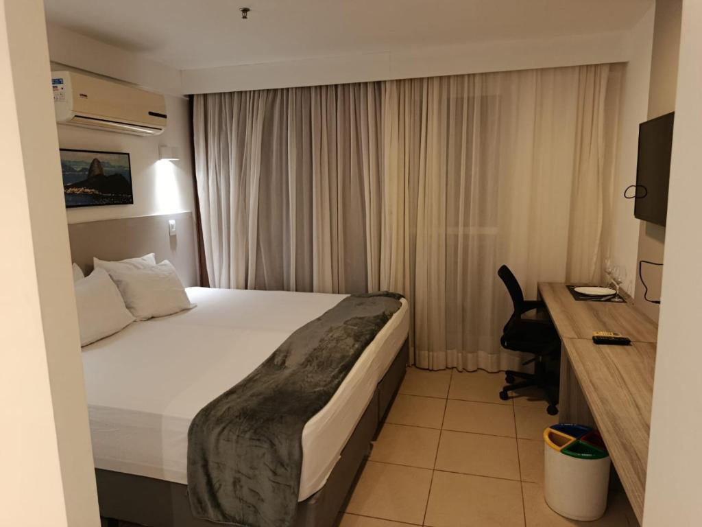 una habitación de hotel con una cama y un escritorio en Flat 519, en Macaé
