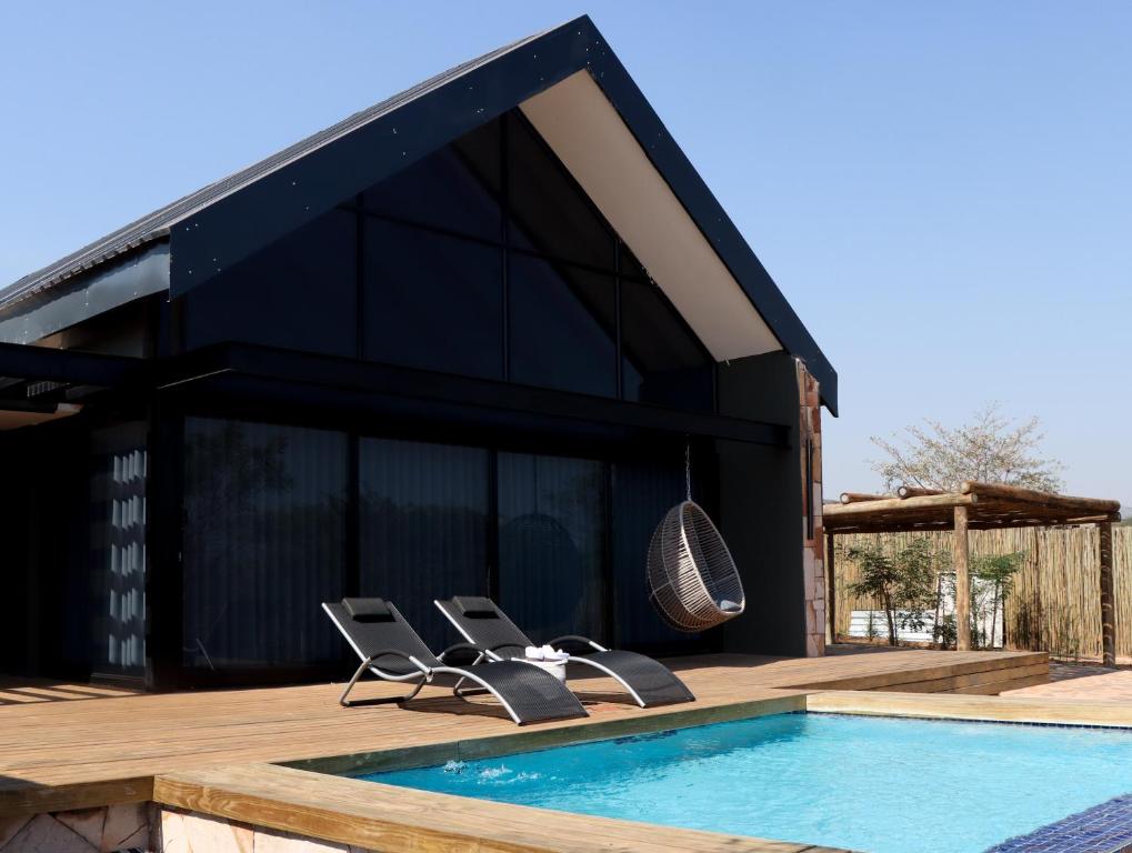 a group of chairs sitting next to a swimming pool at Makonde river lodge in Makonde