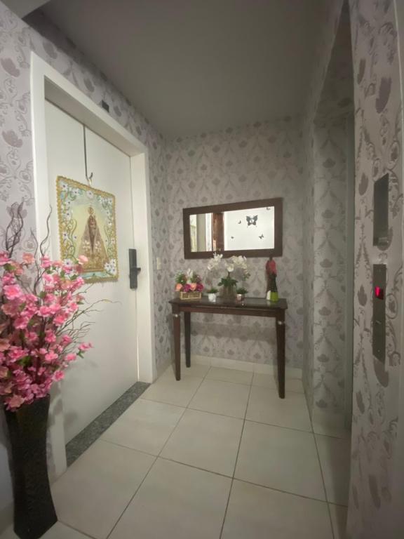 - un couloir avec une table et des fleurs dans la chambre dans l'établissement Por do Sol, conforto e praticidade na COP 30-Batista Campos, à Belém