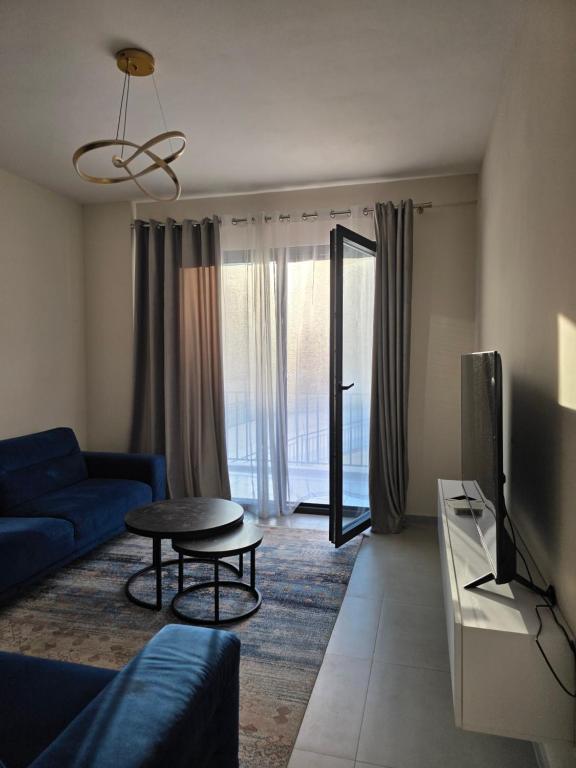 a living room with a blue couch and a tv at Mira Apartment in Tirana