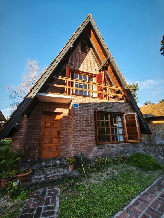 a house with a gambrel roof with a porch at Alpino Mitre in Mar de Ajó