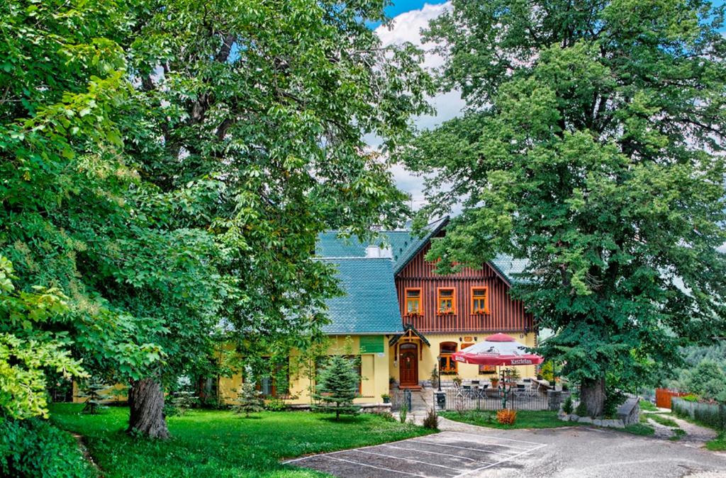 una casa grande con techo azul y árboles en Willa Chatka Puchatka en Piechowice