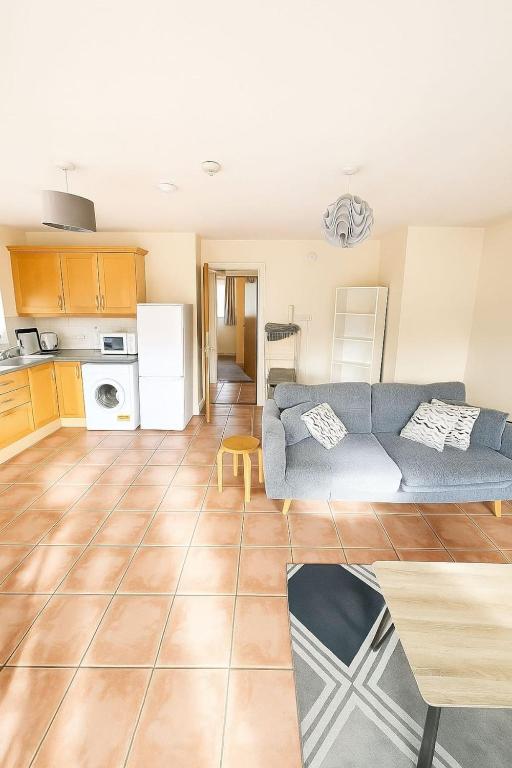 Entire rental unit in Cork, Ireland في كورك: غرفة معيشة مع أريكة زرقاء ومطبخ
