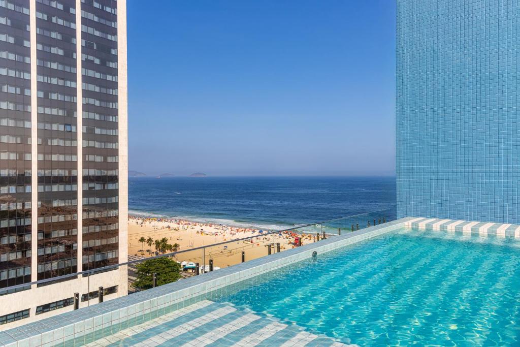 - une piscine sur le côté d'un bâtiment avec une plage dans l'établissement Casa Rio Copacabana, à Rio de Janeiro