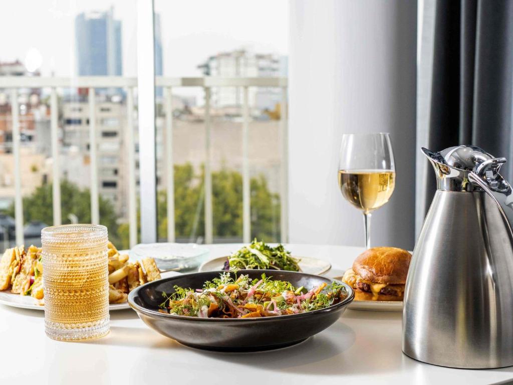 een tafel met een kom eten en een glas wijn bij Mondrian Mexico City Condesa in Mexico-Stad