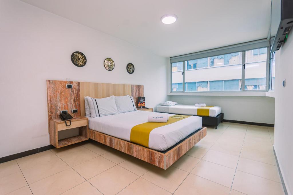 a bedroom with two beds and a window at Mandala Medellín Centro By GyC Hotels in Medellín