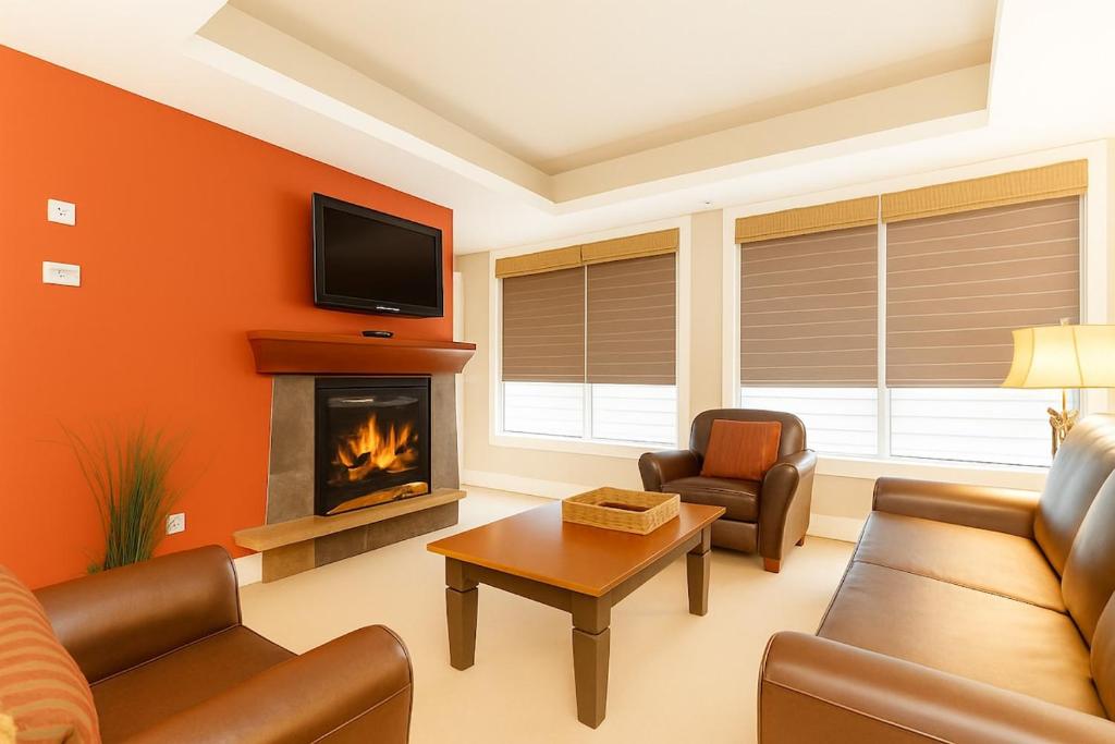 a living room with a couch and a fireplace at Mountain Bliss Spacious 2BR with Pool and Hot Tub in Canmore