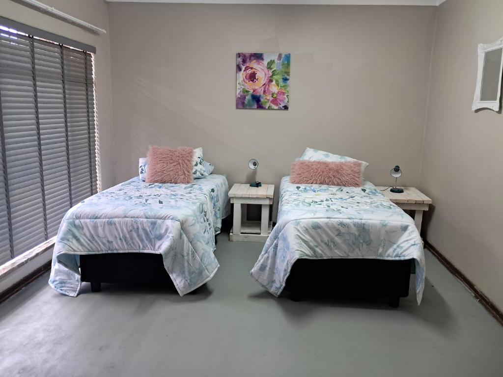 a bedroom with two beds and a window at Greenfield in Klerksdorp