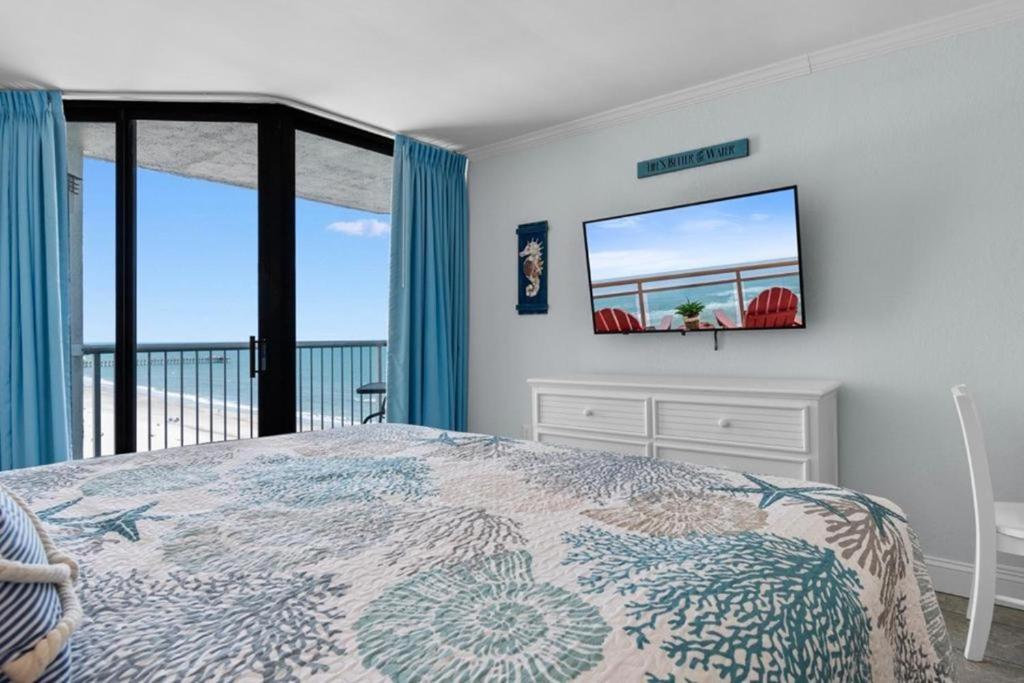 a bedroom with a bed with a view of the ocean at Sandy Horizon in Myrtle Beach
