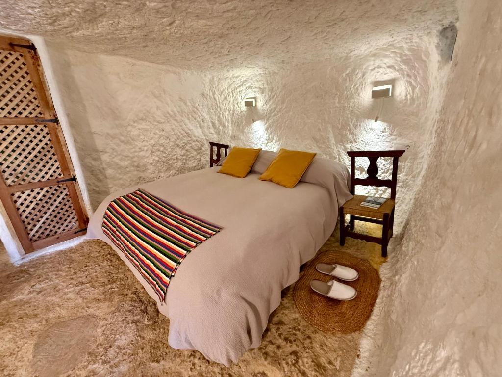 ein Schlafzimmer mit einem Bett in einer Steinhöhle in der Unterkunft Magical Cave in Spain - Boutique Luxury Stay in Nature in Chinchilla de Monte-Aragón