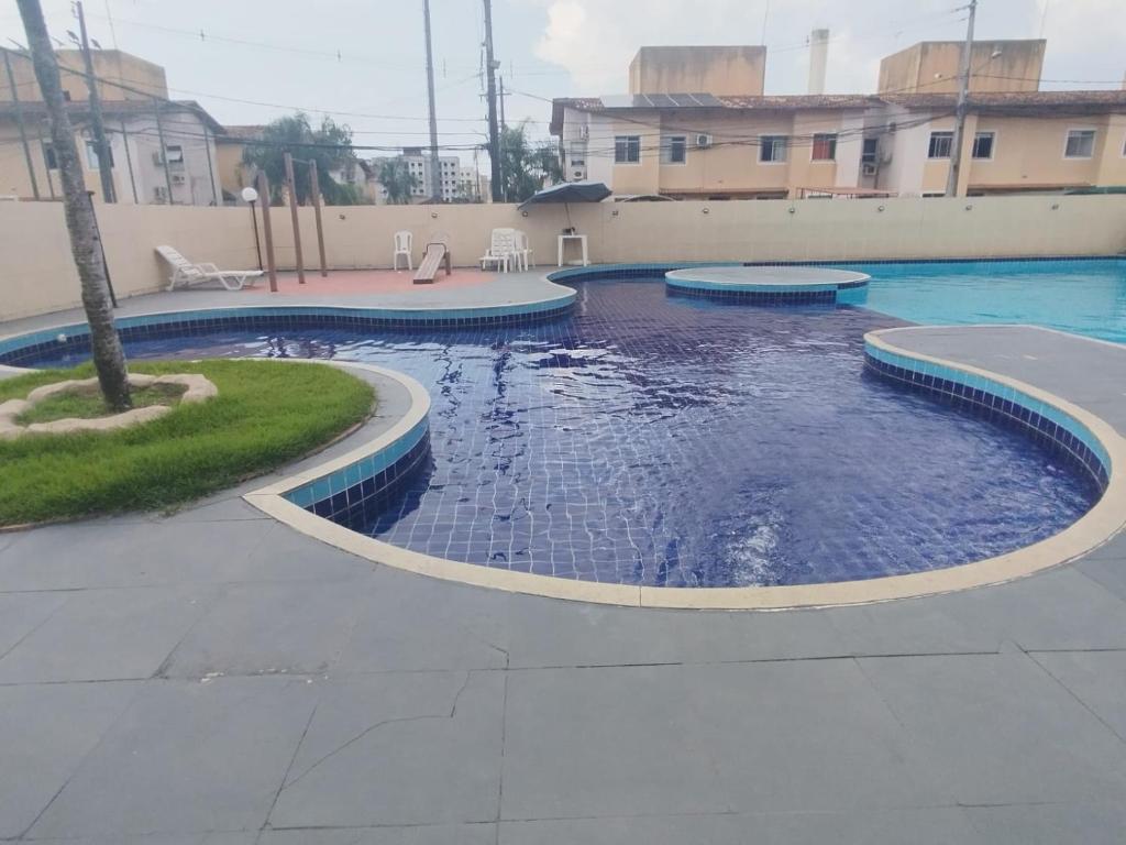 a swimming pool with blue water in a yard at Apartamento paid'egua completo em Belém in Belém
