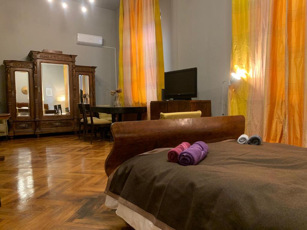a bedroom with a bed with purple slippers on it at Vintage Room in private house in Bucharest