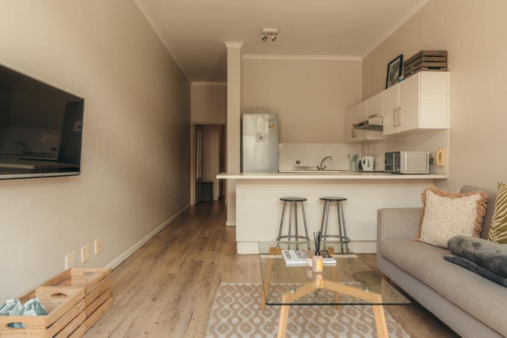 un salon avec un canapé et une cuisine dans l'établissement Sunwave at Empire, au Cap