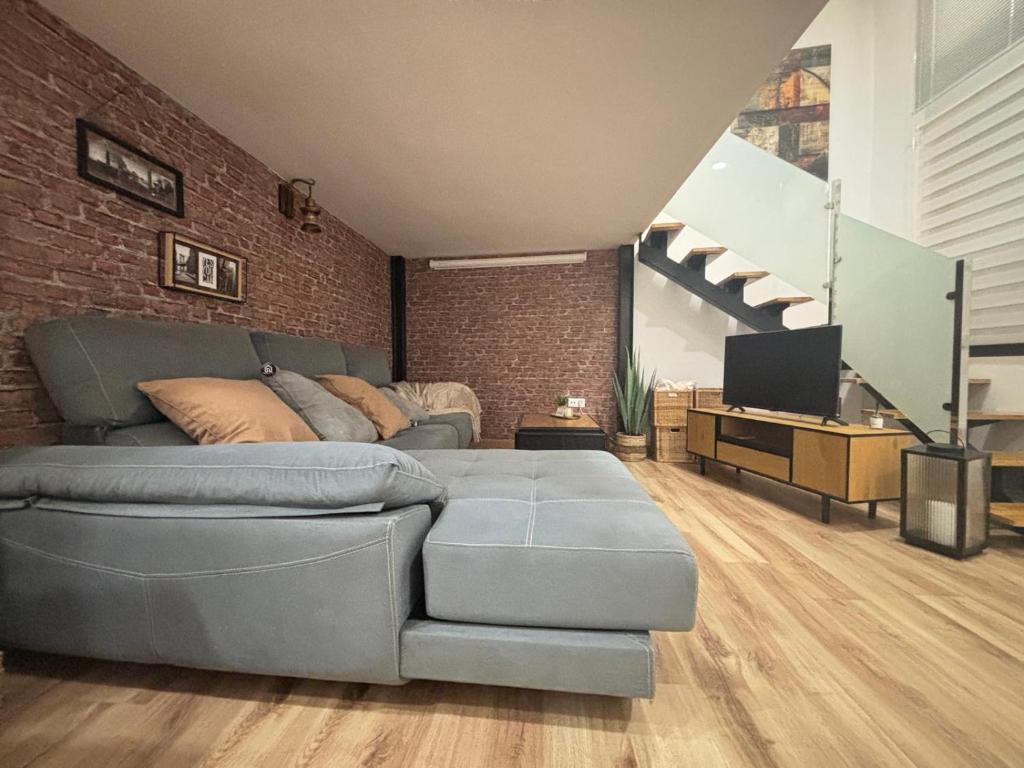 un salon avec un canapé et un mur de briques dans l'établissement Jaén Interior LOFT, à Andújar