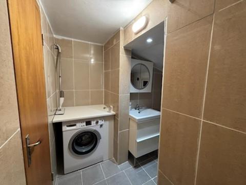 a bathroom with a washing machine and a sink at Stuga in Gothenburg
