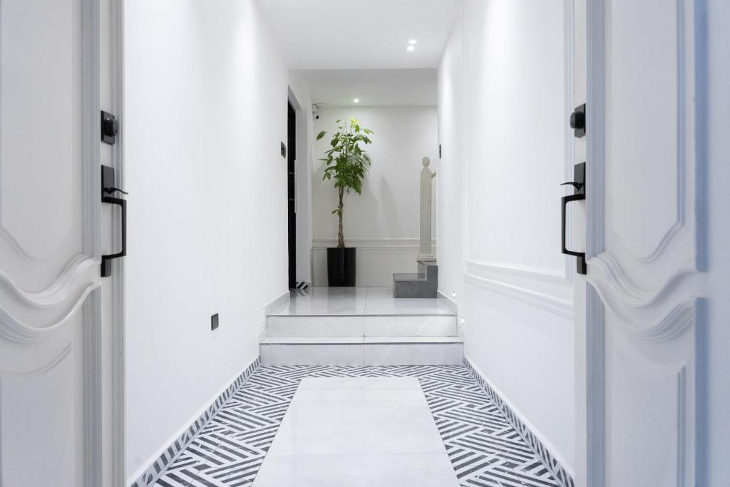 a hallway with white walls and black and white flooring at Hotel Boutique Las Mesetas in San Pedro Sula