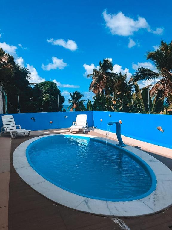 a pool with a mermaid statue in the middle of it at Refúgio Lumare in Maragogi