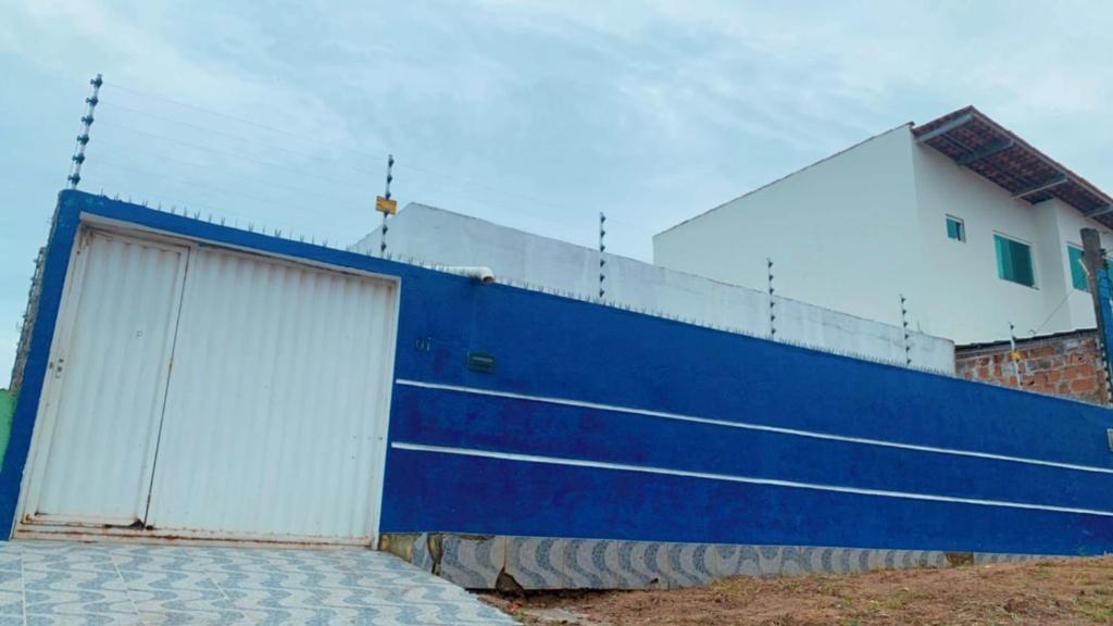 a blue and white wall with two garage doors at Refúgio Lumare in Maragogi