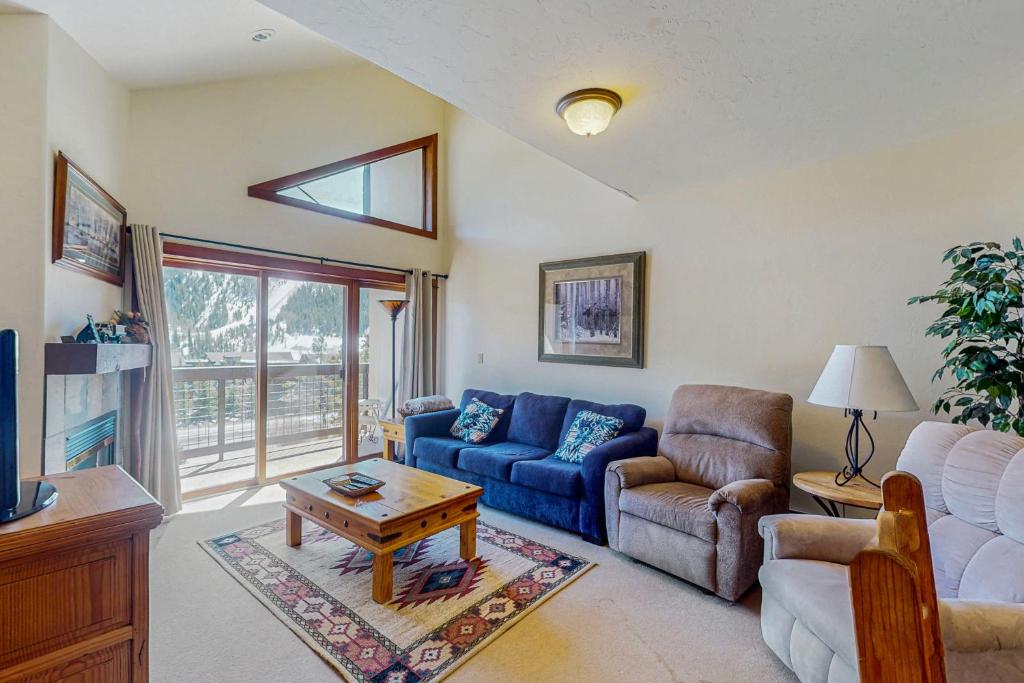 ein Wohnzimmer mit einem blauen Sofa und einem Tisch in der Unterkunft Oro Grande 416 in Snake River Health Services Incorporated Heliport