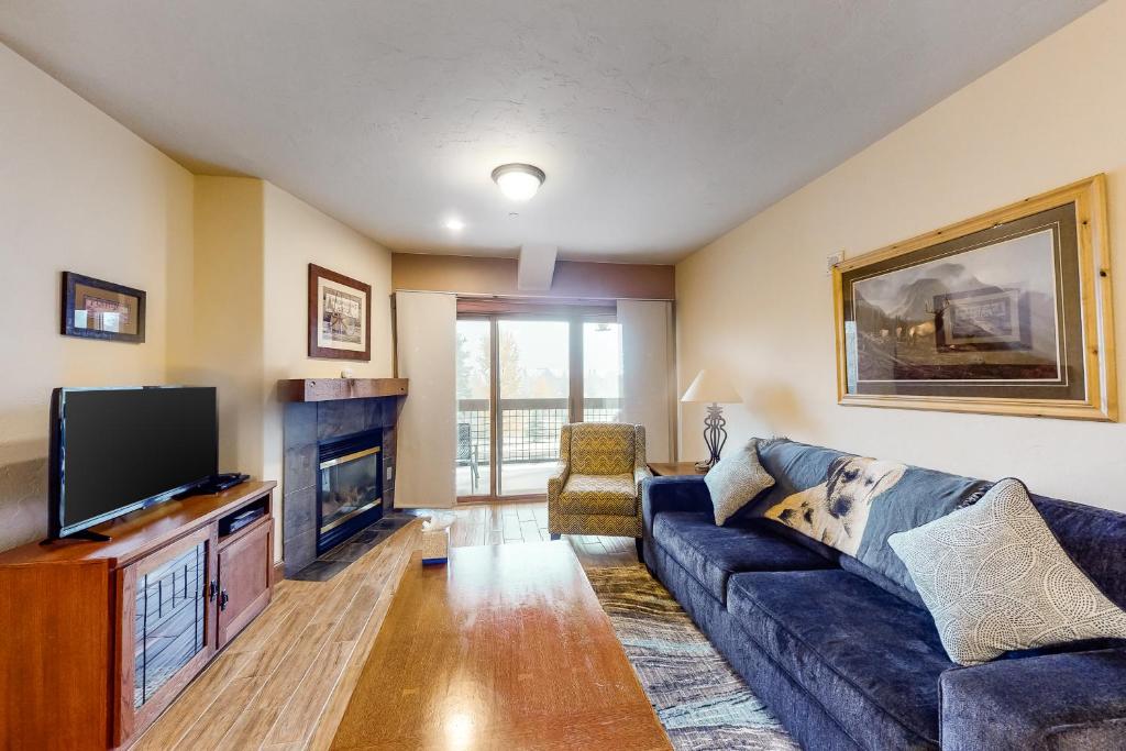 a living room with a blue couch and a tv at Oro Grande 216 in Keystone
