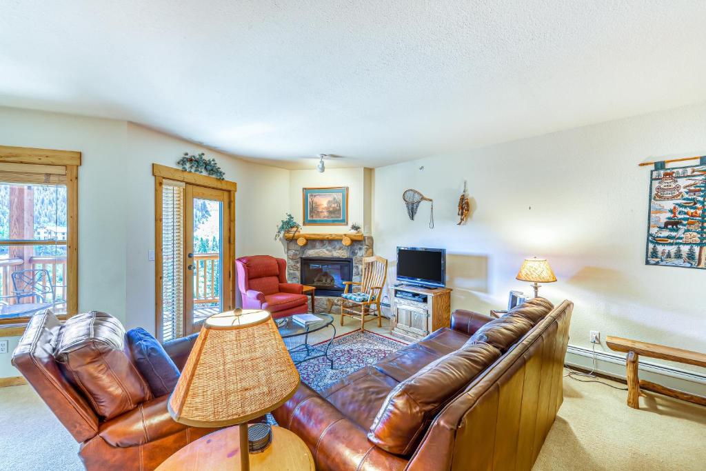 ein Wohnzimmer mit Ledercouch und Fernseher in der Unterkunft Tenderfoot Lodge 2664 in Snake River Health Services Incorporated Heliport