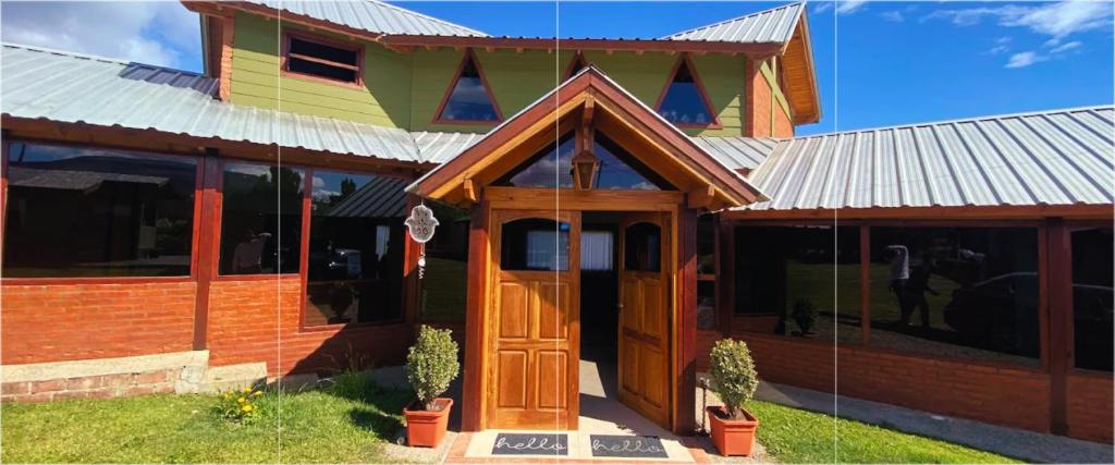 a building with a wooden door in front of it at Ruca Nel in El Calafate
